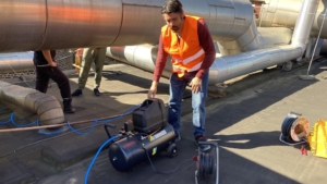 Dr. Tyll Utesch von Colipi entnimmt mit einem Kompressor CO2-haltige Abluft für Experimente.