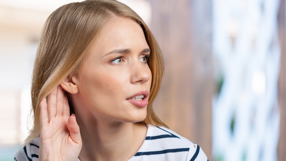 young woman listening gossips and holding her hand near the ear Mit Gene edting gegen den genetisch bedingten Hörverlust. Die Technologie dazu kommt aus Dresden und findet großes Interesse bei Eli Lilly.