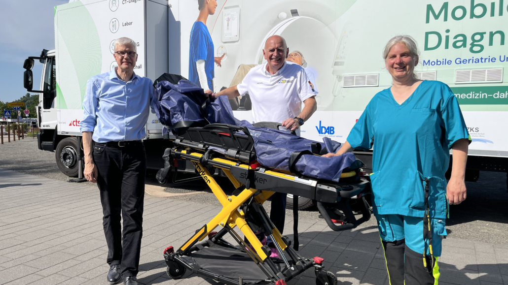mtz.de_Dikom_Team_außen Prof. Dr. Klaus Faßbender, Axel Jung und die Ärztliche Leiterin der Mobilen Geriatrie Unit, Silvia Rauen, (v.l.) vor dem Lkw mit Hightech-Diagnostik